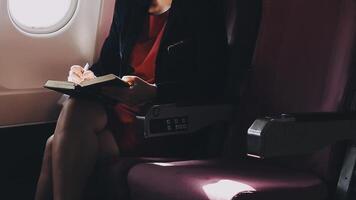 jeune femme asiatique utilisant un ordinateur portable assis près des fenêtres en première classe en avion pendant le vol, les voyages et le concept d'entreprise video