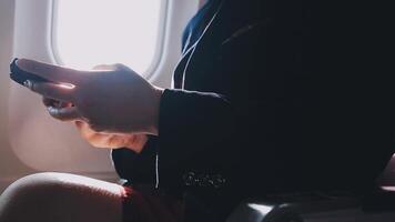 jovem asiática usando laptop sentado perto de janelas na primeira classe no avião durante o voo, viagem e conceito de negócios video