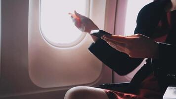 Asian young woman using laptop sitting near windows at first class on airplane during flight,Traveling and Business concept video