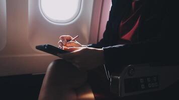 jovem asiática usando laptop sentado perto de janelas na primeira classe no avião durante o voo, viagem e conceito de negócios video