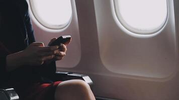 jovem asiática usando laptop sentado perto de janelas na primeira classe no avião durante o voo, viagem e conceito de negócios video