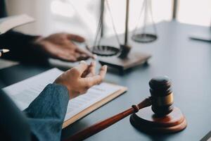 Justice and law concept.Male judge in a courtroom with the gavel, working with, computer and docking keyboard, eyeglasses, on table in morning light photo