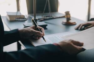 Justice and law concept.Male judge in a courtroom with the gavel, working with, computer and docking keyboard, eyeglasses, on table in morning light photo