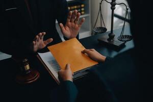 Justice and law concept.Male judge in a courtroom with the gavel, working with, computer and docking keyboard, eyeglasses, on table in morning light photo