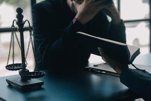 Justice and law concept.Male judge in a courtroom with the gavel, working with, computer and docking keyboard, eyeglasses, on table in morning light photo