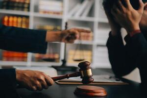 Justice and law concept.Male judge in a courtroom with the gavel, working with, computer and docking keyboard, eyeglasses, on table in morning light photo