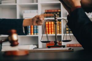 Justice and law concept.Male judge in a courtroom with the gavel, working with, computer and docking keyboard, eyeglasses, on table in morning light photo