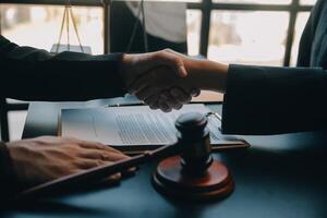 Justice and law concept.Male judge in a courtroom with the gavel, working with, computer and docking keyboard, eyeglasses, on table in morning light photo