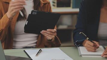 Business team working with new startup project plan and discussion information for financial strategy with laptop and digital tablet in a modern business lounge. video
