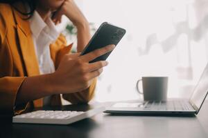 el retrato de una joven mujer asiática independiente está trabajando en su trabajo en una tableta de computadora en una oficina moderna. hacer un informe de análisis contable datos de inversión inmobiliaria, concepto de sistemas financieros y fiscales. foto