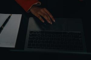 Asian Business woman using calculator and laptop for doing math finance on an office desk, tax, report, accounting, statistics, and analytical research concept photo