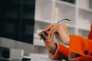 Asian Business woman using calculator and laptop for doing math finance on an office desk, tax, report, accounting, statistics, and analytical research concept photo