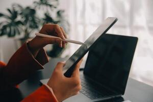 Asian Business woman using calculator and laptop for doing math finance on an office desk, tax, report, accounting, statistics, and analytical research concept photo