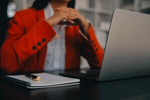 Asian Business woman using calculator and laptop for doing math finance on an office desk, tax, report, accounting, statistics, and analytical research concept photo