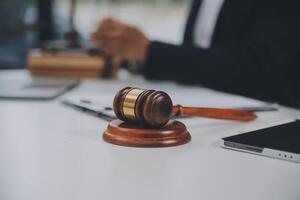 Business and lawyers discussing contract papers with brass scale on desk in office. Law, legal services, advice, justice and law concept picture with film grain effect photo