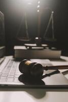 image of judge's hammer, scales lady of justice, law book, laptop computer and contract documents with pen concept of law and justice. photo