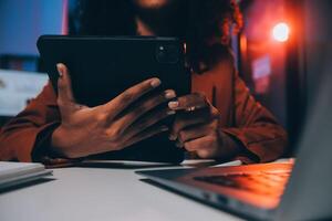 mujer sentado a su escritorio en hogar oficina trabajando tarde a noche utilizando ordenador portátil computadora hembra web diseñador trabajando tiempo extraordinario remotamente desde hogar foto