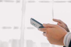 Young woman using apps on a mobile touchscreen smartphone. Concept for using technology, shopping online, mobile apps, texting, addiction, swipe up, swipe down. photo