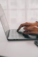 Business woman using mobile phone during working on laptop computer, surfing the internet, searching business data at modern office. Asian businesswoman online working on computer at workplace photo