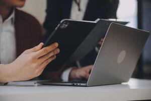Financial analysts analyze business financial reports on a digital tablet planning investment project during a discussion at a meeting of corporate showing the results of their successful teamwork. photo