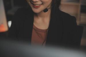 Young woman working in call centre, surrounded by colleagues photo