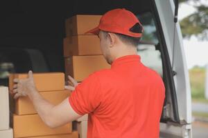 Asian delivery express courier young man use giving boxes to woman customer he wearing protective face mask at front home photo