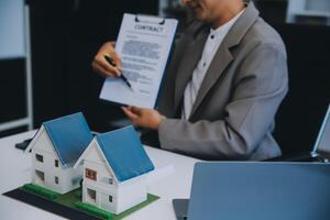 Real estate agent talked about the terms of the home purchase agreement and asked the customer to sign the documents to make the contract legally, Home sales and home insurance concept. photo