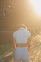 Young fitness woman runner stretching legs before run on city photo