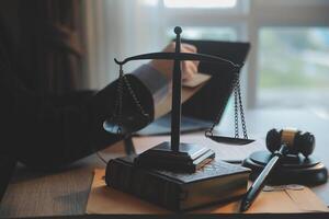 Business and lawyers discussing contract papers with brass scale on desk in office. Law, legal services, advice, justice and law concept picture with film grain effect photo