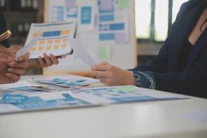 Close up ux developer and ui designer use augmented reality brainstorming about mobile app interface wireframe design on desk at modern office.Creative digital development agency photo