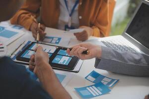 Close up ux developer and ui designer use augmented reality brainstorming about mobile app interface wireframe design on desk at modern office.Creative digital development agency photo