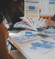 Close up ux developer and ui designer use augmented reality brainstorming about mobile app interface wireframe design on desk at modern office.Creative digital development agency photo