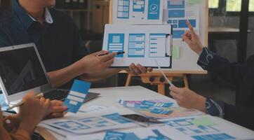 Close up ux developer and ui designer use augmented reality brainstorming about mobile app interface wireframe design on desk at modern office.Creative digital development agency photo