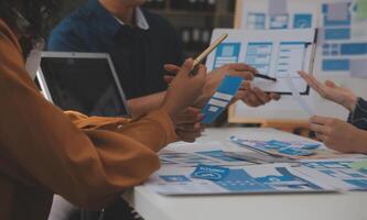 Close up ux developer and ui designer use augmented reality brainstorming about mobile app interface wireframe design on desk at modern office.Creative digital development agency photo