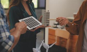 eléctrico ingeniero con empresario que se discute nuevo proyecto instalación solar célula panel en el techo de edificio. alternativa energía concepto. foto