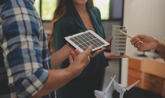 eléctrico ingeniero con empresario que se discute nuevo proyecto instalación solar célula panel en el techo de edificio. alternativa energía concepto. foto