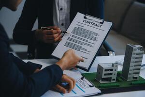 Real estate agent talked about the terms of the home purchase agreement and asked the customer to sign the documents to make the contract legally, Home sales and home insurance concept. photo