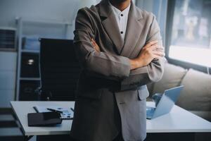 Happy businessman dressed in suit in modern office using tablet photo