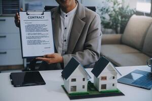 Real estate agent talked about the terms of the home purchase agreement and asked the customer to sign the documents to make the contract legally, Home sales and home insurance concept. photo