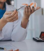 los dentistas están discutiendo problemas dentales al informar la imagen de rayos X en la pantalla del portátil a los pacientes. foto