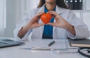 Doctor explaining heart to elderly patient. Doctor explaining the heart model. Doctors pen point to a model of the heart photo