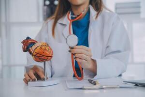 Doctor explaining heart to elderly patient. Doctor explaining the heart model. Doctors pen point to a model of the heart photo