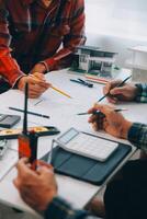 engineer people meeting working and pointing at a drawings in office for discussing. Engineering tools and construction concept. photo