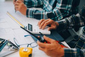 ingeniero personas reunión trabajando y señalando a un dibujos en oficina para que se discute. Ingenieria herramientas y construcción concepto. foto