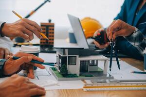 imagen de ingeniero reunión para arquitectónico proyecto. trabajando con compañero y Ingenieria herramientas en lugar de trabajo Clásico tono. foto