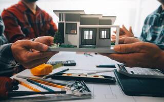 engineer people meeting working and pointing at a drawings in office for discussing. Engineering tools and construction concept. photo