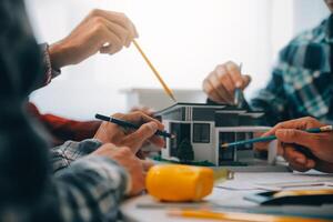 engineer people meeting working and pointing at a drawings in office for discussing. Engineering tools and construction concept. photo
