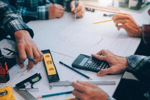 ingeniero personas reunión trabajando y señalando a un dibujos en oficina para que se discute. Ingenieria herramientas y construcción concepto. foto