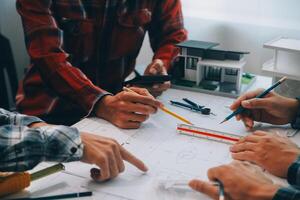 engineer people meeting working and pointing at a drawings in office for discussing. Engineering tools and construction concept. photo