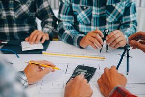 engineer people meeting working and pointing at a drawings in office for discussing. Engineering tools and construction concept. photo